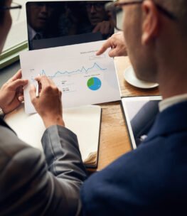 Business people analyzing visitors activity statistics, view over the shoulder
